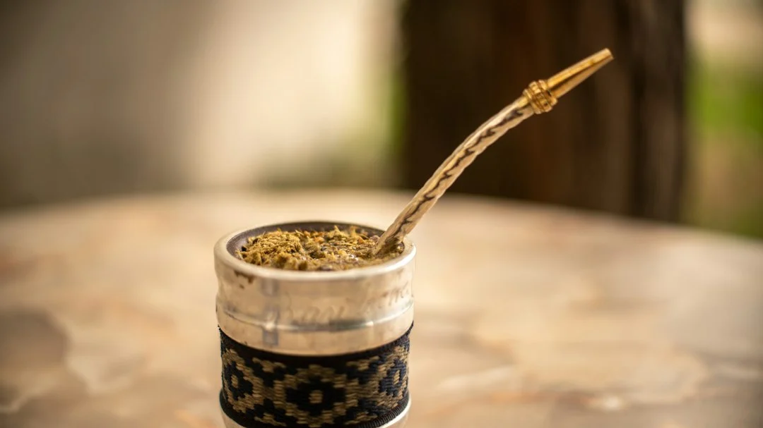 Mate-Becher mit Yerba Mate und Bombilla auf einem Tisch im Freien