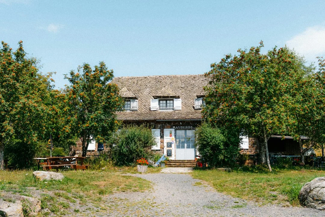 Rustikales Landhaus zwischen Bäumen unter klarem Himmel