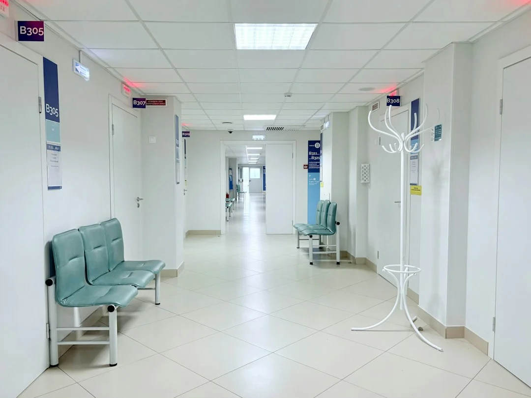 Leerer Krankenhausflur mit Sitzbänken und Türen