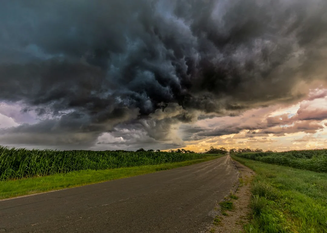 Dunkle Gewitterwolken ziehen über flaches Ackerland