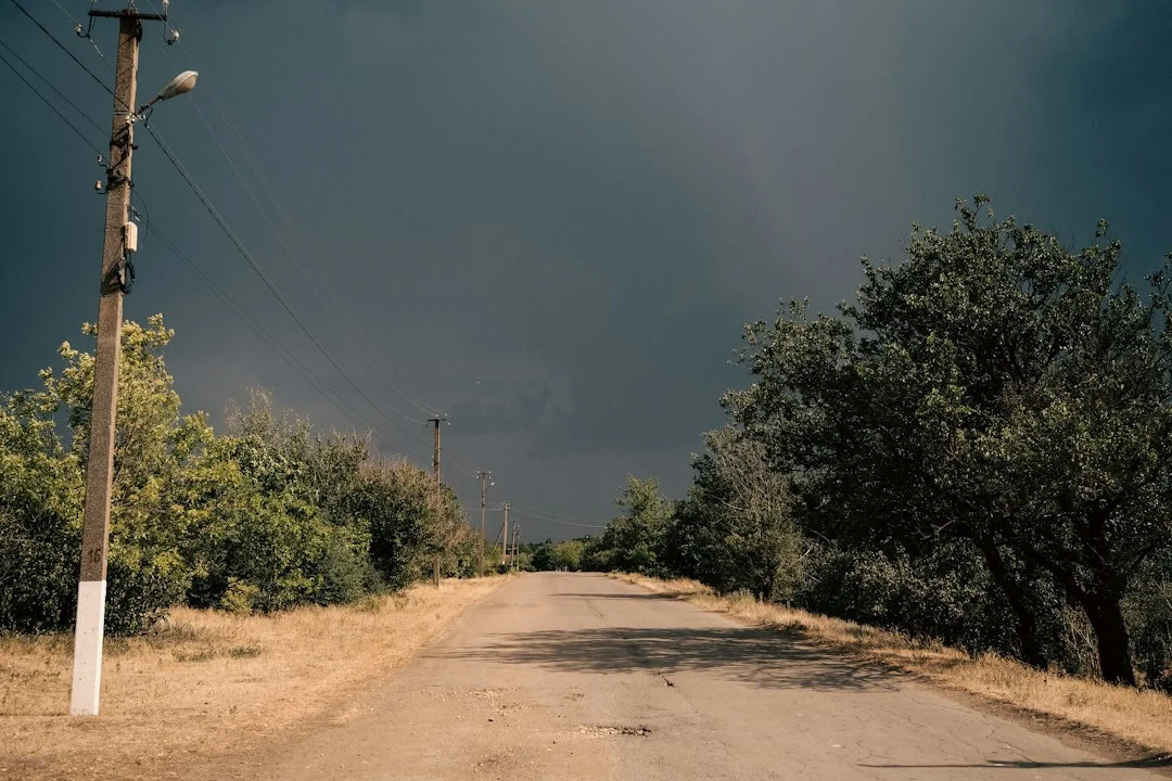Unbefestigte Landstraße unter dunklen Gewitterwolken