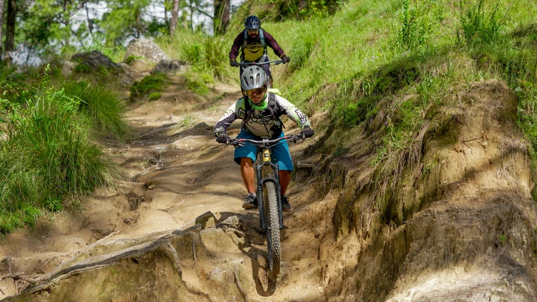 Zwei Mountainbiker fahren auf einem unbefestigten Feldweg